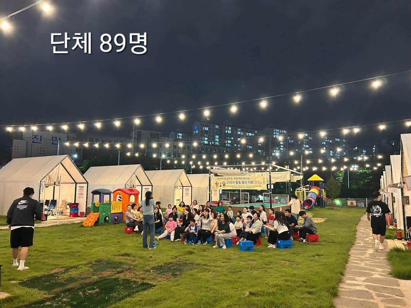 89명 단체가 잔디광장에 모여 프로그램을 진행하는 모습